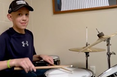 boy playing drumset