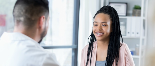 happy teen girl talking to doctor