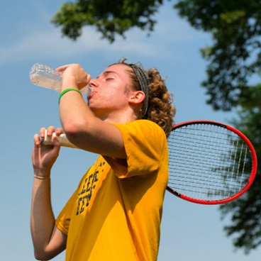 Boy taking a drink break during tennis