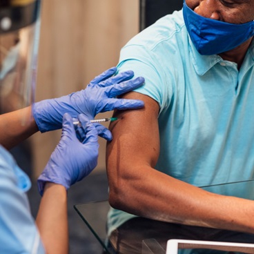 Male patient receiving the COVID-19 vaccination.