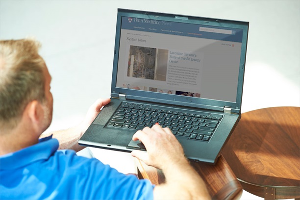 Man using PC laptop checking Penn Medicine News